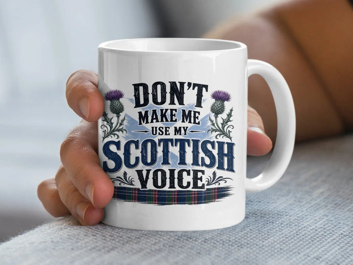 White mug with "Don't make me use my Scottish voice" text and thistle design.