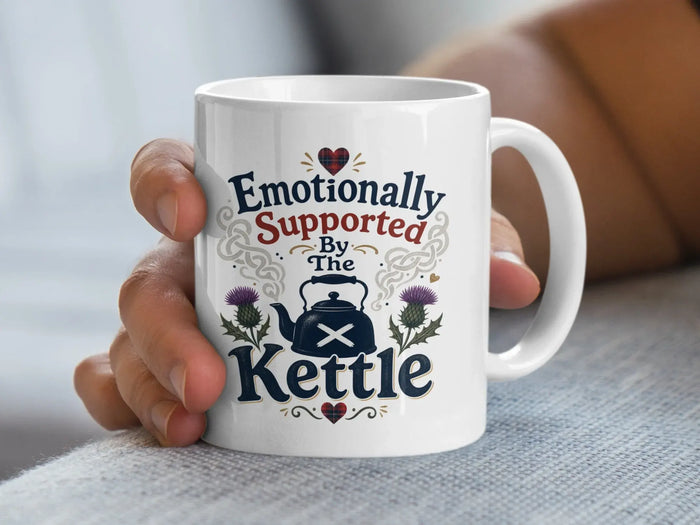 White mug with "Emotionally Supported By The Kettle" text and Scottish thistle design.