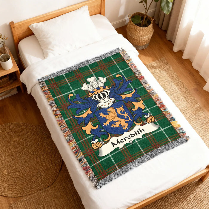 Green tartan blanket with Meredith family crest draped on a bed.