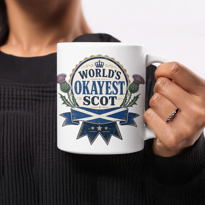 Mug with "World's Okayest Scot" and Scottish flag design.