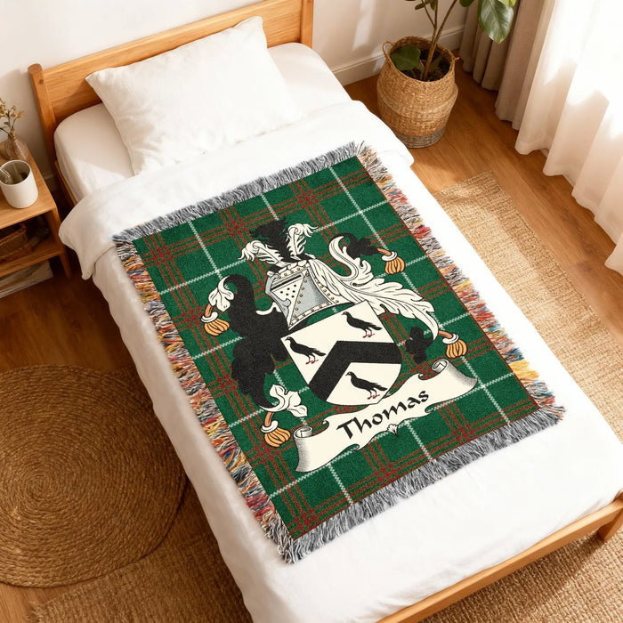 Green tartan woven throw blanket with "Thomas" family crest and birds.